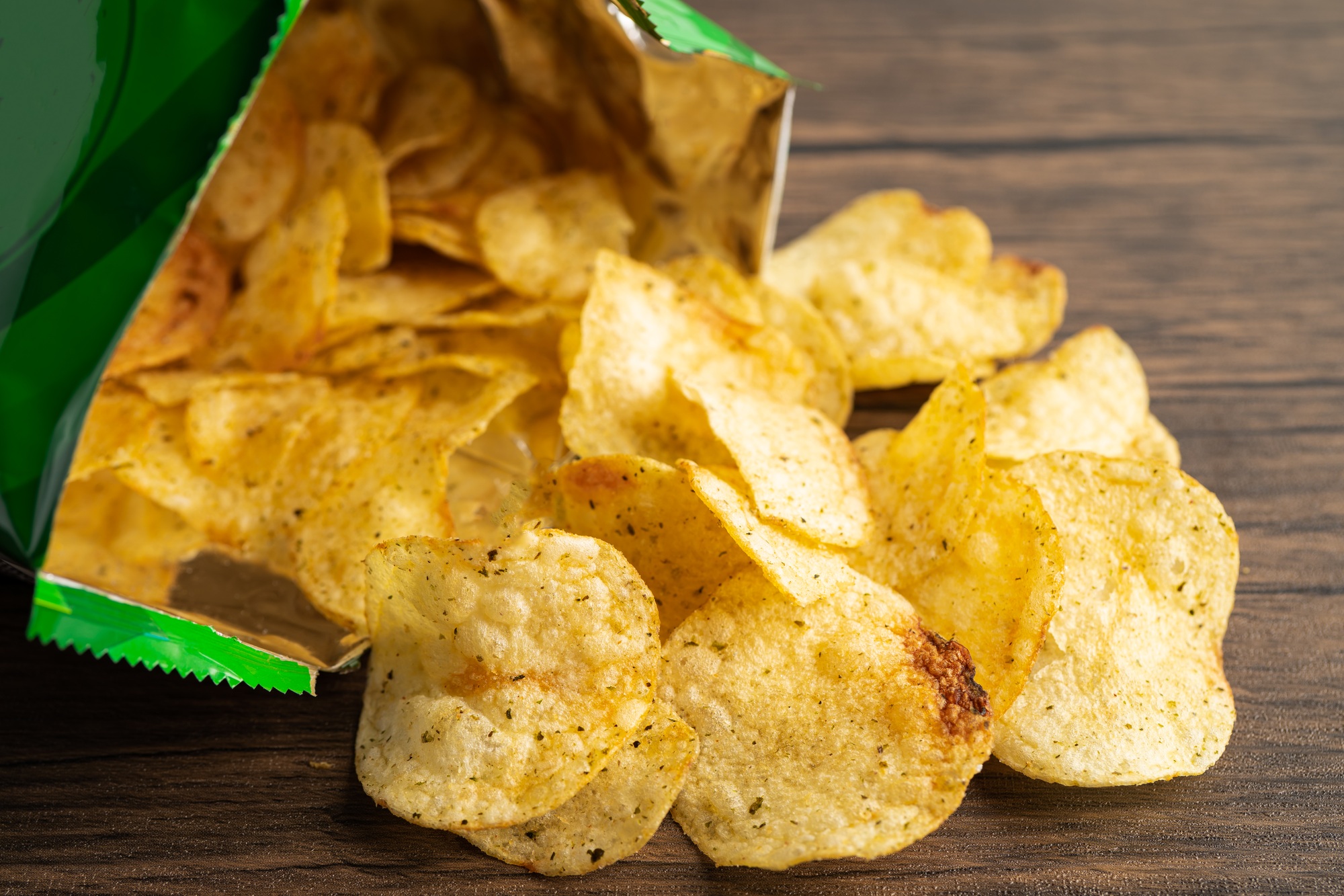 Potato chips, delicious spicy for crips, thin slice deep fried snack fast food in open bag.